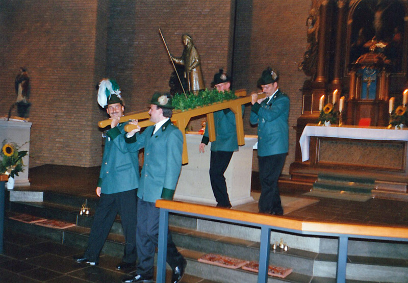 Vier Schützenbrüder tragen die Statue vom Altar der Kirche